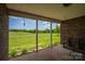 Back porch with a swing overlooking a lush green lawn and trees in the distance, creating a tranquil retreat at 5873 Alexis Ln, Vale, NC 28168