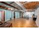 Partially finished basement with exposed ceiling, wood flooring, and bright blue accent walls at 5873 Alexis Ln, Vale, NC 28168
