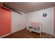 Basement bedroom with a crib and beadboard accent wall painted white with pink accents at 5873 Alexis Ln, Vale, NC 28168