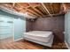 Spacious basement bedroom showcasing a brick accent wall, wood-look flooring, and light-colored walls at 5873 Alexis Ln, Vale, NC 28168