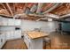 Basement kitchen with an island that features a butcher block top and seating, and a subway tile backsplash at 5873 Alexis Ln, Vale, NC 28168