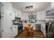 Bright kitchen featuring white cabinetry, stainless steel appliances, and stylish backsplash at 5873 Alexis Ln, Vale, NC 28168