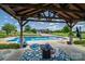 Relaxing poolside view with covered patio, outdoor ceiling fan, and backyard at 5873 Alexis Ln, Vale, NC 28168