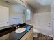 Well-lit bathroom featuring a modern vanity with dark countertop and a clean, white tub and shower combination at 668 Smith St, Kannapolis, NC 28083
