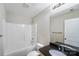 Bright bathroom with a white tub enclosure, toilet, and a vanity with black countertop and updated fixtures at 668 Smith St, Kannapolis, NC 28083