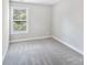 Carpeted bedroom featuring a window with blinds allowing natural light into the space at 668 Smith St, Kannapolis, NC 28083