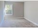Bright bedroom with plush carpeting and a large window offering a view of the surrounding greenery at 668 Smith St, Kannapolis, NC 28083