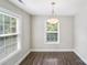 Inviting dining room featuring wood-look flooring, a modern chandelier, and natural light from large windows at 668 Smith St, Kannapolis, NC 28083