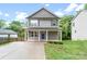 Charming two-story home features a blue front door, covered porch with white columns, and a well-maintained yard at 668 Smith St, Kannapolis, NC 28083