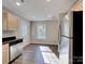 Cozy kitchen showcasing stainless steel dishwasher and fridge with wood-style flooring at 668 Smith St, Kannapolis, NC 28083