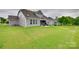 Exterior view of backyard featuring lush lawn and a covered patio at 7049 Irongate Dr, Indian Land, SC 29707