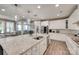 Bright kitchen boasts a large granite island, stainless steel appliances, and white cabinetry at 7049 Irongate Dr, Indian Land, SC 29707