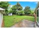 Lush backyard with mature trees, a fire pit, and a detached garage, perfect for outdoor entertaining and storage at 7412 Woodstream Dr, Charlotte, NC 28210