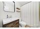 Bright bathroom featuring a modern vanity with sink, updated fixtures, and a shower with a white curtain at 7412 Woodstream Dr, Charlotte, NC 28210