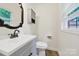 Cozy bathroom featuring an ornate mirror, stylish vanity with sink, and a well-placed medicine cabinet for storage at 7412 Woodstream Dr, Charlotte, NC 28210