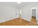 Clean, minimalist bedroom with hardwood floors, neutral walls, and ample natural light coming in from the windows at 7412 Woodstream Dr, Charlotte, NC 28210