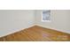 Bright, cozy bedroom featuring hardwood floors and a large window at 7412 Woodstream Dr, Charlotte, NC 28210