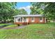 Charming home with brick and siding, bay window, landscaped yard, and inviting curb appeal at 7412 Woodstream Dr, Charlotte, NC 28210