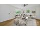 Staged living room with hardwood floors, neutral furniture, and a bay window at 7412 Woodstream Dr, Charlotte, NC 28210