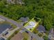 An aerial view of a home highlighting property lines in a residential neighborhood surrounded by lush trees at 83 Woodsdale Se Pl, Concord, NC 28025