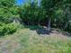 This spacious backyard with green grass and lush vegetation presents an outdoor paradise at 83 Woodsdale Se Pl, Concord, NC 28025