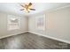 This bedroom features two windows, ceiling fan, and light neutral colored walls and floors at 83 Woodsdale Se Pl, Concord, NC 28025
