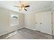Neutrally painted bedroom with a window, ceiling fan, and a double door closet at 83 Woodsdale Se Pl, Concord, NC 28025