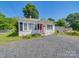 Charming one-story home with a red door, black shutters, white siding, and a gravel driveway at 83 Woodsdale Se Pl, Concord, NC 28025