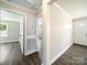 Hallway with wood-look flooring, neutral walls, and doorways leading to different rooms in the house at 83 Woodsdale Se Pl, Concord, NC 28025