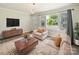 Cozy living room with a modern chandelier, a neutral-toned sofa set, and a view of the outdoors at 83 Woodsdale Se Pl, Concord, NC 28025
