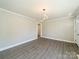 Spacious room featuring modern light fixture, wood-look floors, neutral walls, and ample natural light at 83 Woodsdale Se Pl, Concord, NC 28025