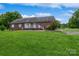Well-maintained backyard of a brick home featuring a lush green lawn and mature trees at 8520 Wright Rd, Kannapolis, NC 28081