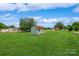 Large backyard featuring a storage shed with green lawn and a clear blue sky at 8520 Wright Rd, Kannapolis, NC 28081
