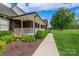 Brick home with a long, covered porch, lush landscaping and a walkway at 8520 Wright Rd, Kannapolis, NC 28081