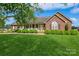 Beautiful brick home featuring a welcoming front porch and verdant lawn at 8520 Wright Rd, Kannapolis, NC 28081