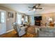 Cozy living room with hardwood floors, ceiling fan, fireplace, and comfortable beige furniture at 8520 Wright Rd, Kannapolis, NC 28081