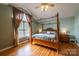 Bright main bedroom with ceiling fan, hardwood floor, and a four poster bed at 8520 Wright Rd, Kannapolis, NC 28081