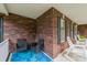 Covered brick porch featuring outdoor seating and charming decor with an overhead roof at 8520 Wright Rd, Kannapolis, NC 28081