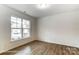 Well-lit bedroom featuring hardwood floors and a large window for natural light at 8619 Frank Grier Rd # 3, Charlotte, NC 28215
