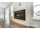 Modern fireplace with a dark surround flanked by windows and light hardwood floors at 8619 Frank Grier Rd # 3, Charlotte, NC 28215