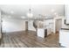 Open-concept living room with hardwood floors, fireplace, and kitchen island at 8619 Frank Grier Rd # 3, Charlotte, NC 28215