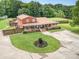 Expansive aerial view of brick home, fenced yard, and inviting outdoor spaces. Mature trees in background at 907 Sikes Mill Rd, Monroe, NC 28110