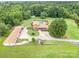 Aerial view of home with in-ground pool, spacious backyard, wooded area, and two garages at 907 Sikes Mill Rd, Monroe, NC 28110