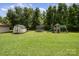 Large backyard with a shed, trampoline, and play set, perfect for outdoor activities at 907 Sikes Mill Rd, Monroe, NC 28110