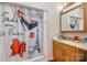 Charming bathroom featuring a shower with a decorative curtain and a wooden vanity at 907 Sikes Mill Rd, Monroe, NC 28110