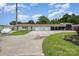 Long white home with multiple garage spaces and a beautiful flower bed at 907 Sikes Mill Rd, Monroe, NC 28110