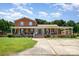 Charming two-story red brick home with a spacious wraparound porch and well-manicured lawn at 907 Sikes Mill Rd, Monroe, NC 28110