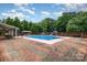 Outdoor pool area featuring an in-ground pool with two slides and brick patio at 907 Sikes Mill Rd, Monroe, NC 28110
