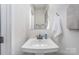 Clean, well-lit half-bath featuring a pedestal sink, modern faucet, and neutral paint at 980 Prince Garrett Way, Denver, NC 28037