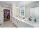 Bright bathroom featuring double sinks, quartz countertops, and an organized walk-in closet at 980 Prince Garrett Way, Denver, NC 28037